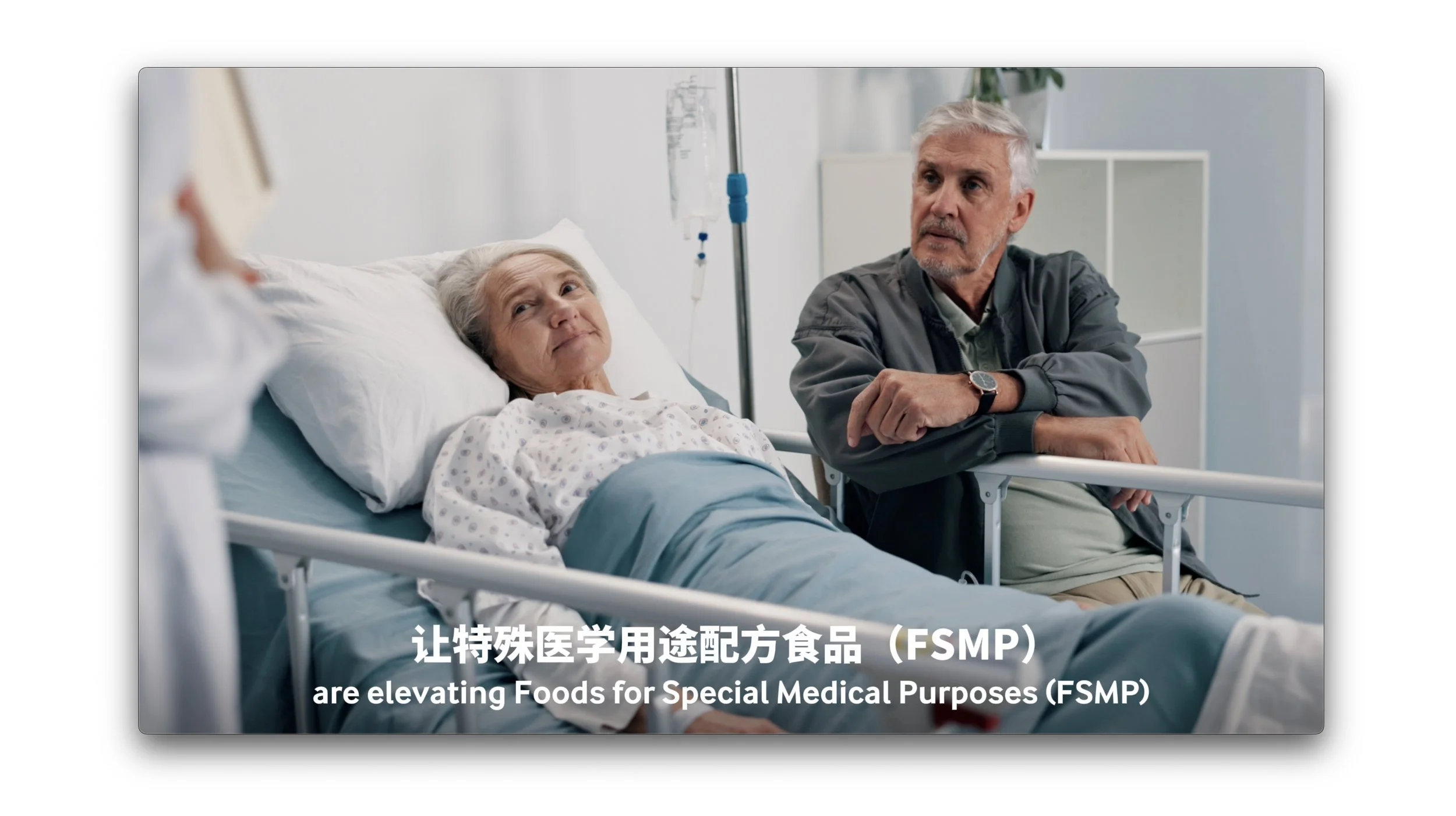 An elderly woman lying in a hospital bed with an IV drip, looking at a nurse holding a notepad, and an elderly man sitting beside her looking concerned, with medical equipment in the background.