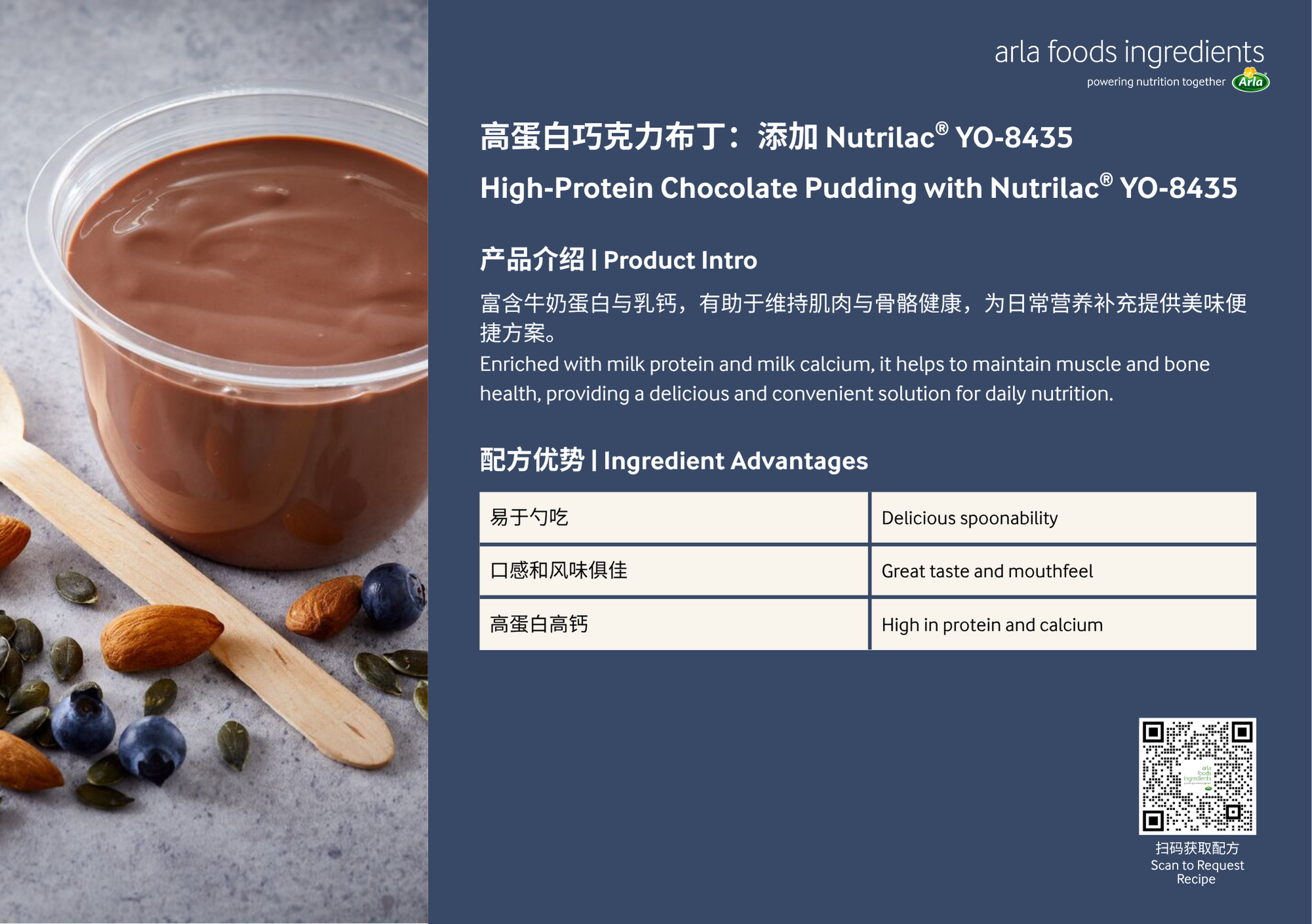 A cup of high-protein chocolate pudding with almonds, blueberries, and pumpkin seeds beside it, alongside a wooden spatula, on a gray surface.