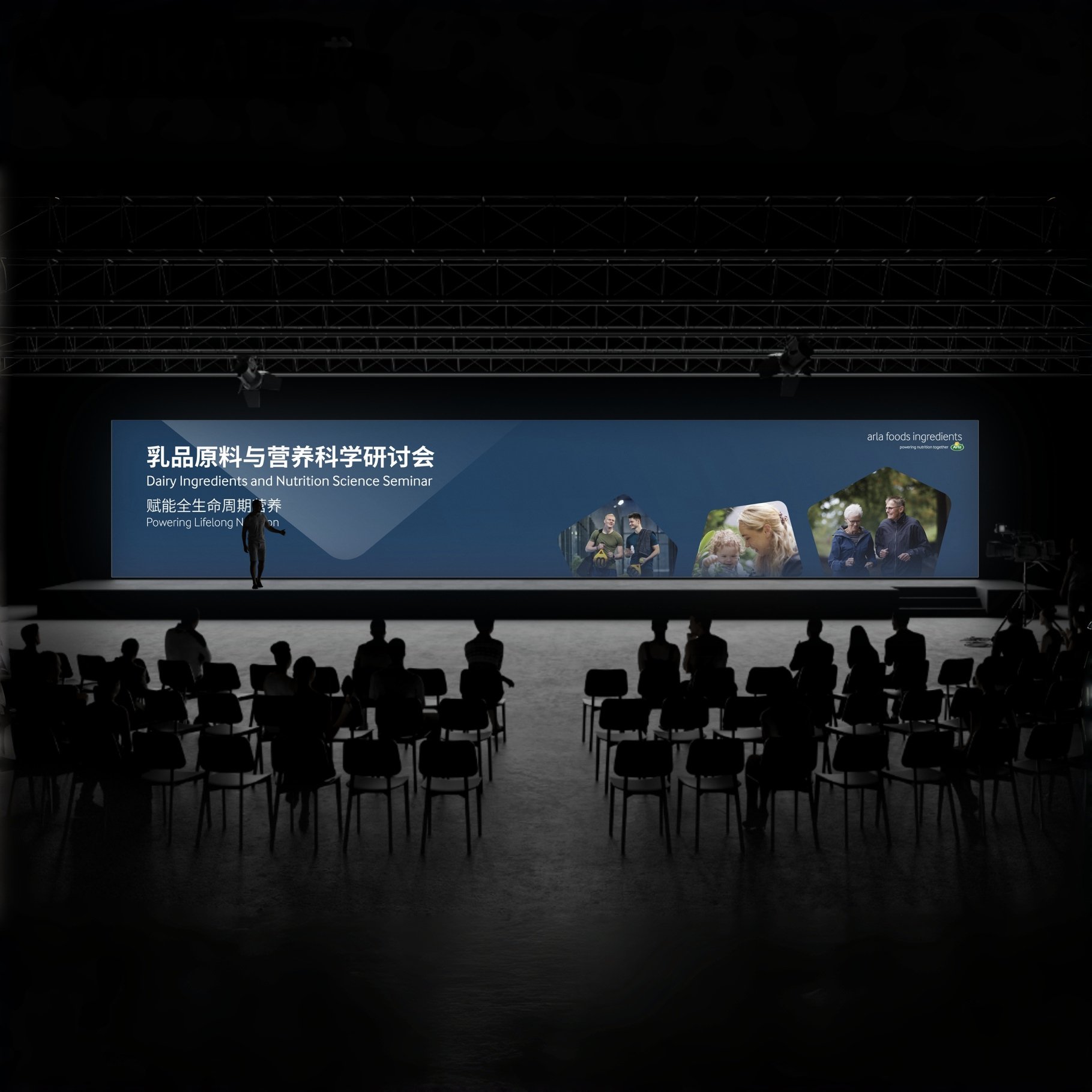 A large conference stage features a blue banner with Chinese and English text about a Dairy Ingredients and Nutrition Science Seminar. Audience members are seated in front, with some silhouettes visible in the darkened room. There are a few people on stage preparing for the event.